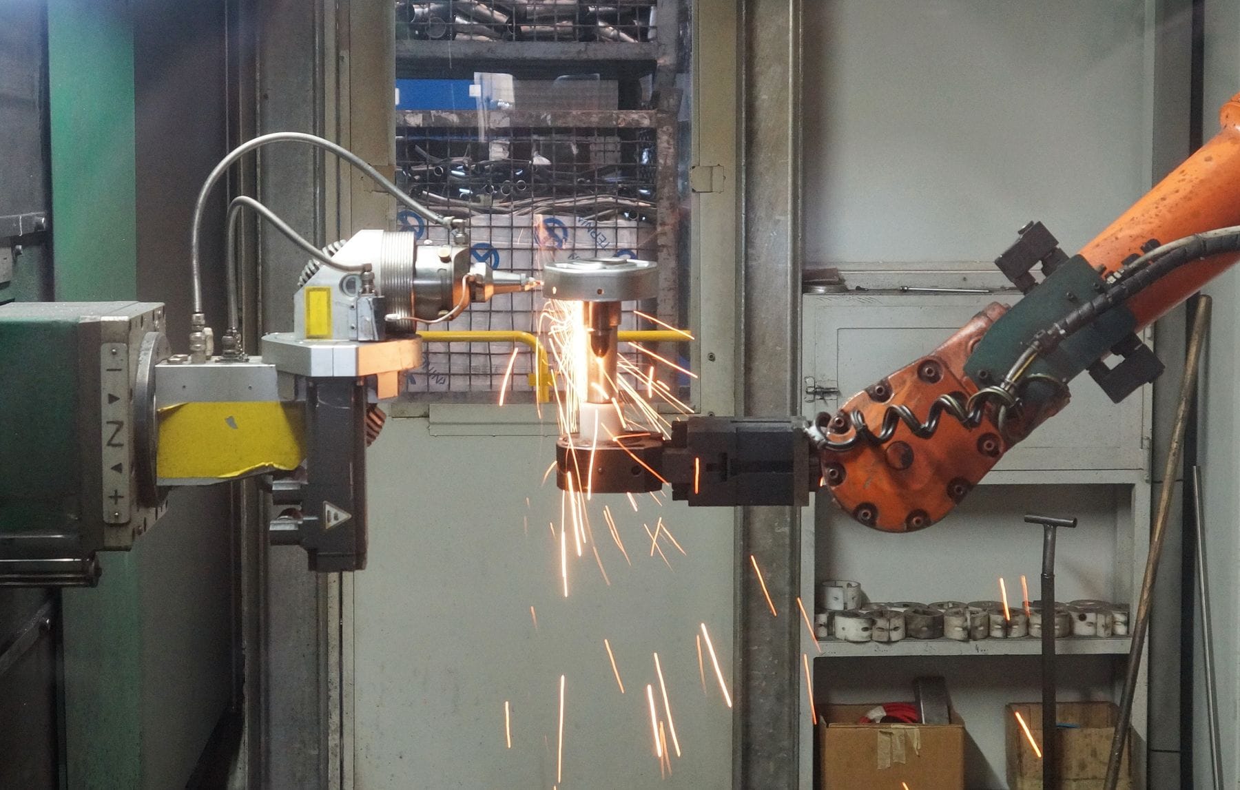 Robotic welding arm throwing sparks on an industrial production line