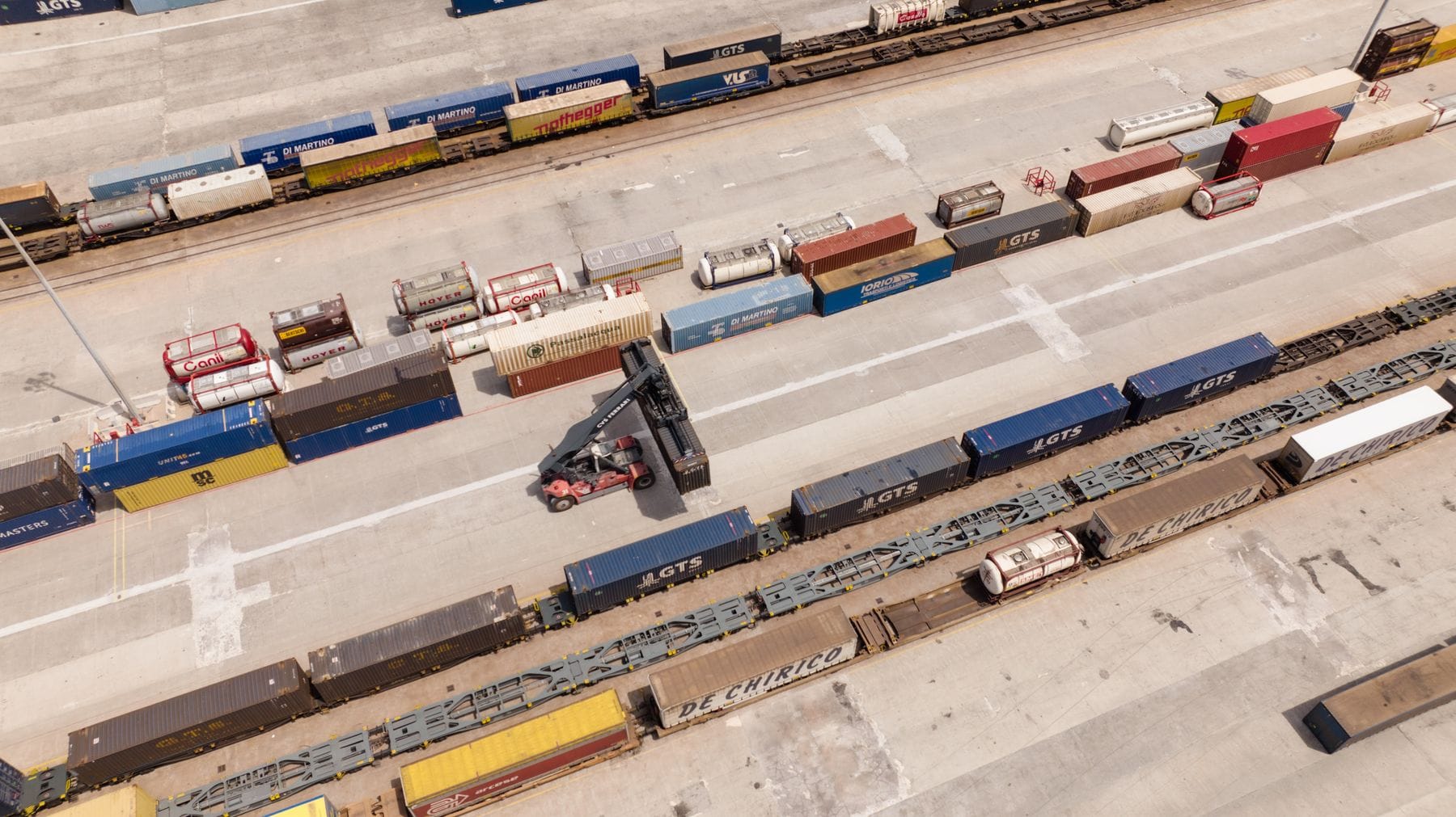 Aerial view of a container yard with rail lines and stacked shipping containers