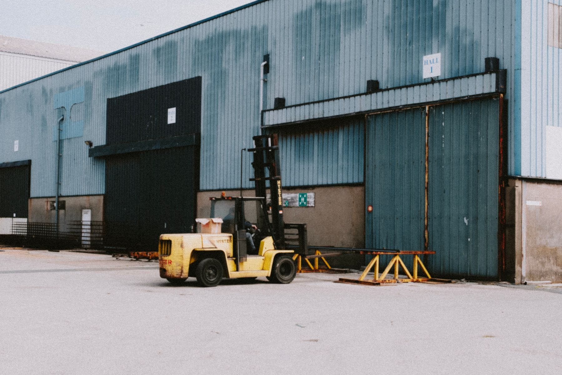 Forklift parked outside the loading doors of an industrial warehouse