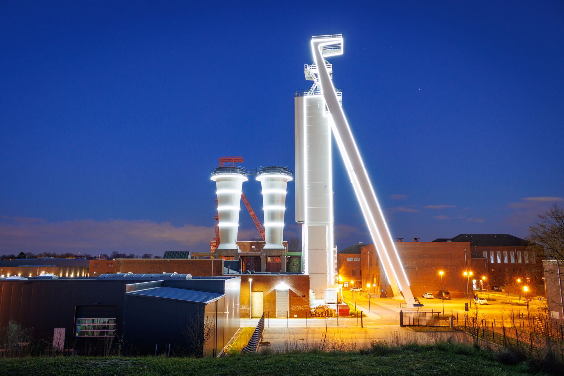Industrial facility lit up at dusk with lights along the perimeter