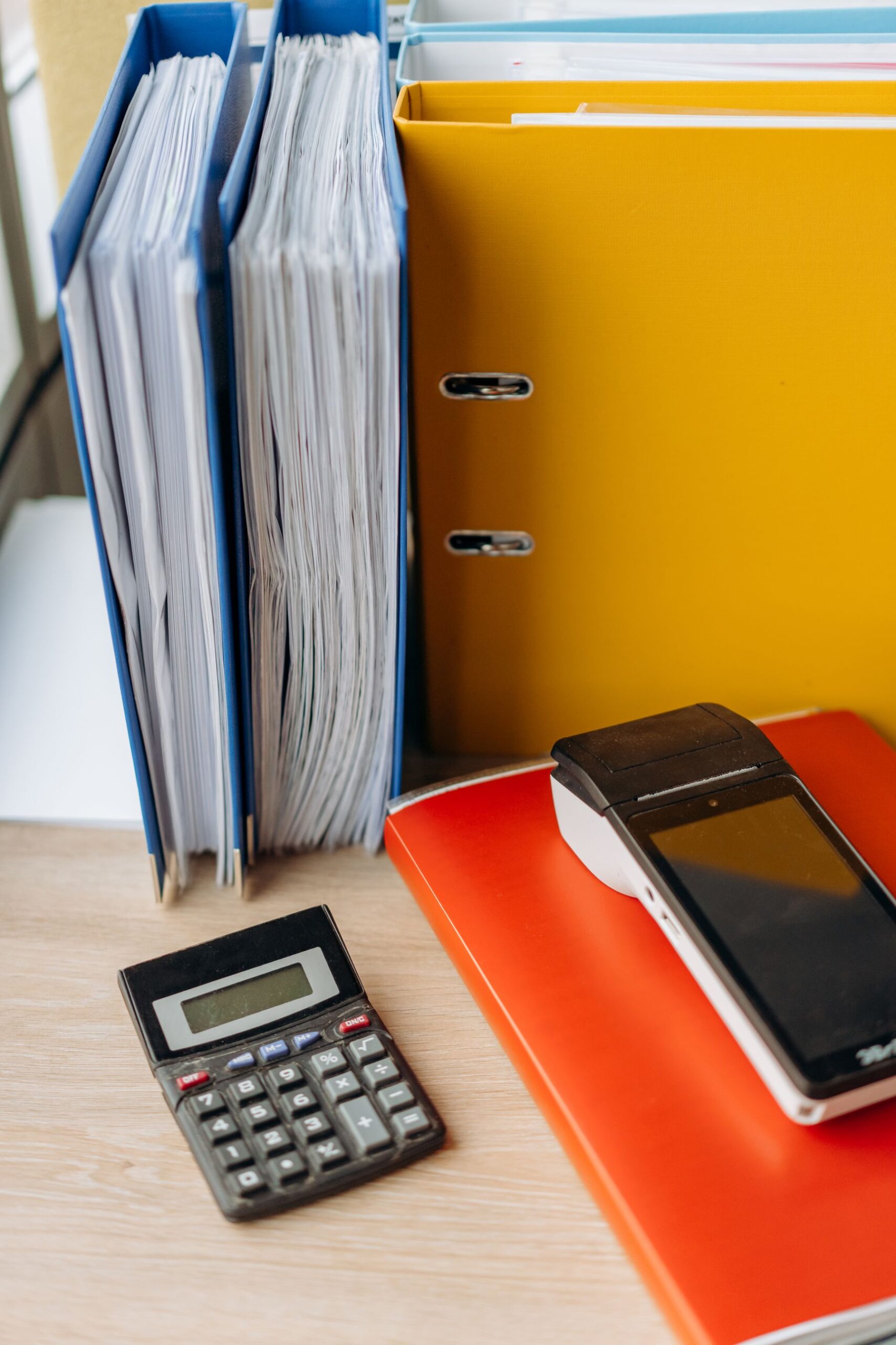 Box files of accounting records stacked beside a calculator