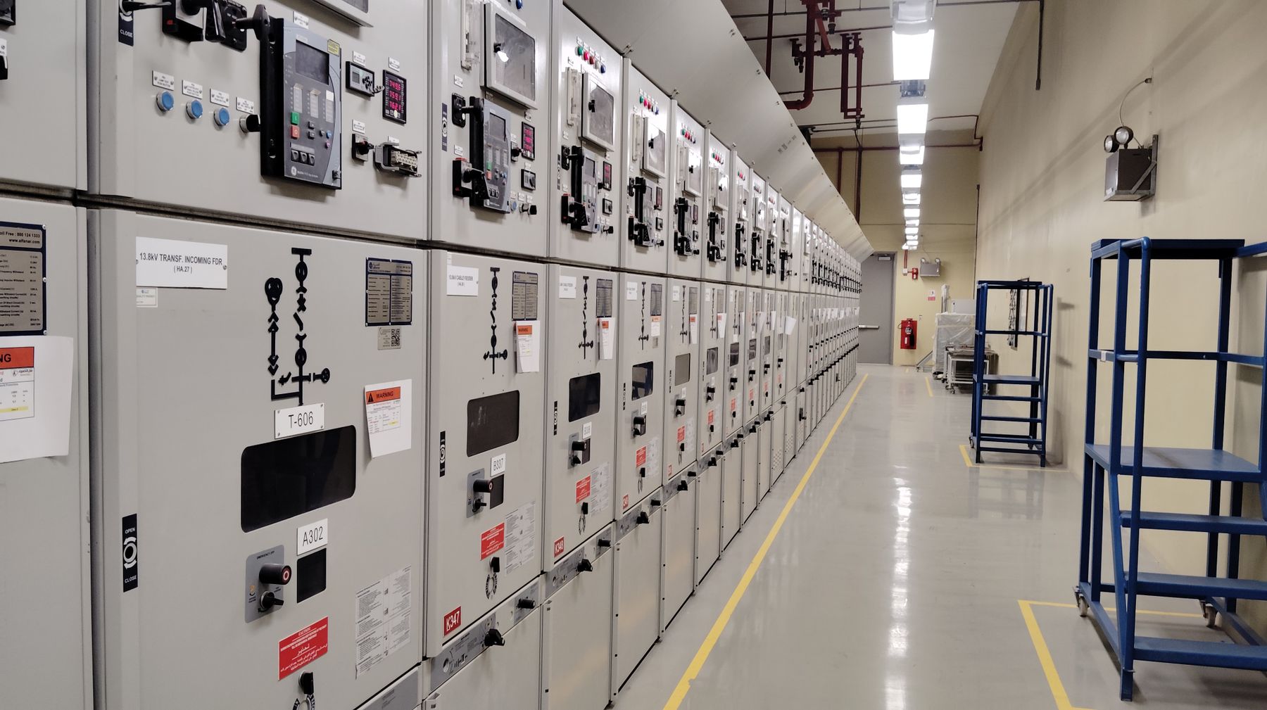 Row of electrical control panels along an industrial corridor
